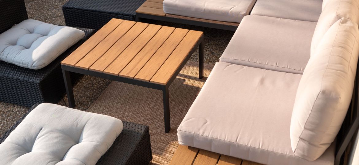 Modern outdoor patio seating with sofa, cushions and table on terrace, close-up garden furniture for relaxation.