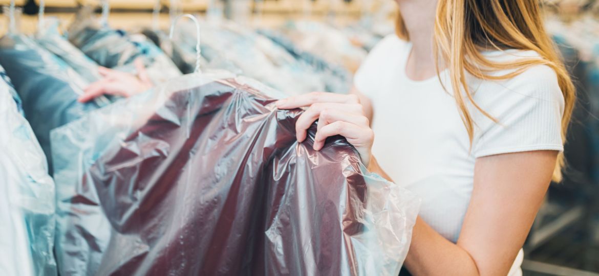 Young female worker in dry-cleaning salon.